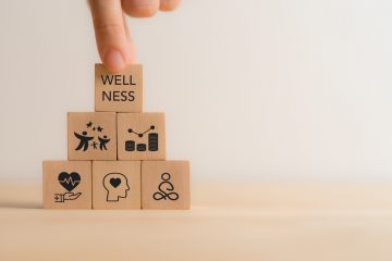 Wellness concept. Wooden cube blocks with health, mindfulness, mental health, happiness, financial stability and growth icons on white background. Balance, integration in achieving overall wellbeing.